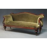 A Victorian mahogany framed settee, with serpentine back and carved scrolling arms, upholstered in