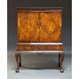 A walnut and inlaid cabinet on stand, early to mid 20th Century, the moulded cornice above two