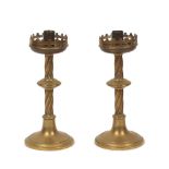 A pair of Victorian Gothic Revival brass altar candlesticks, designed with trefoil gallery above a