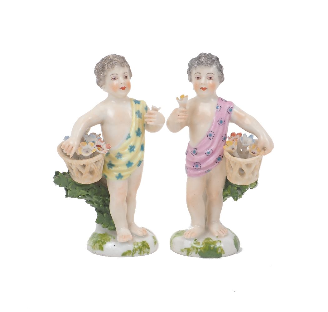 Two Chelsea figurines of flower boys, each designed holding a flower in one hand and basket in the