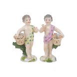 Two Chelsea figurines of flower boys, each designed holding a flower in one hand and basket in the