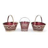 Three Victorian silver sweetmeat baskets with red glass liners, comprising: a pair of oval
