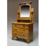 An Arts and Crafts oak dressing chest, circa 1900, having an adjustable mirrored back, with a raised
