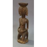 A Dogon figural stand, Mali, second half 20th Century, carved as a kneeling four headed figure, 55cm