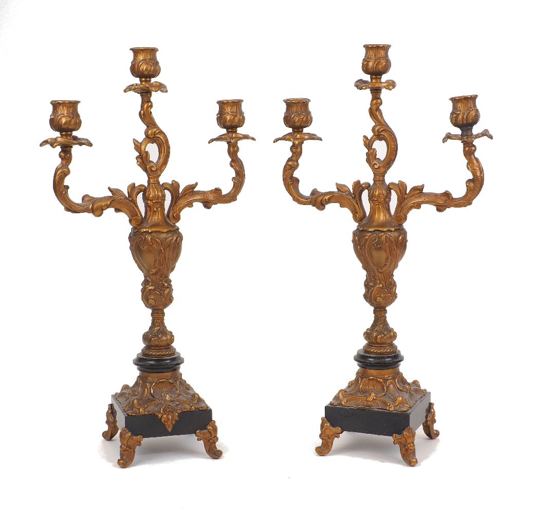 A pair of gilt spelter three light candelabra, 20th century, of Rococo style on black marble