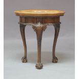 An early 20th Century oak woolwork topped occasional table, the glazed top with a woolwork panel
