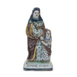 A French faience figure group, 19th Century, depicting St. Anne standing next to a child holding