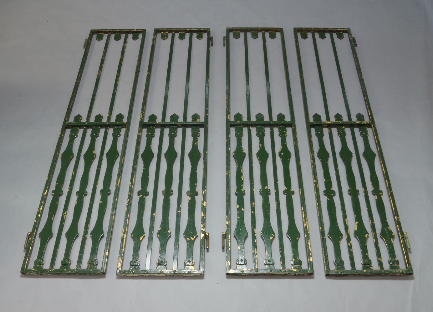 A four sectioned metal gate, early 20th Century, with vertical decorative posts, each section