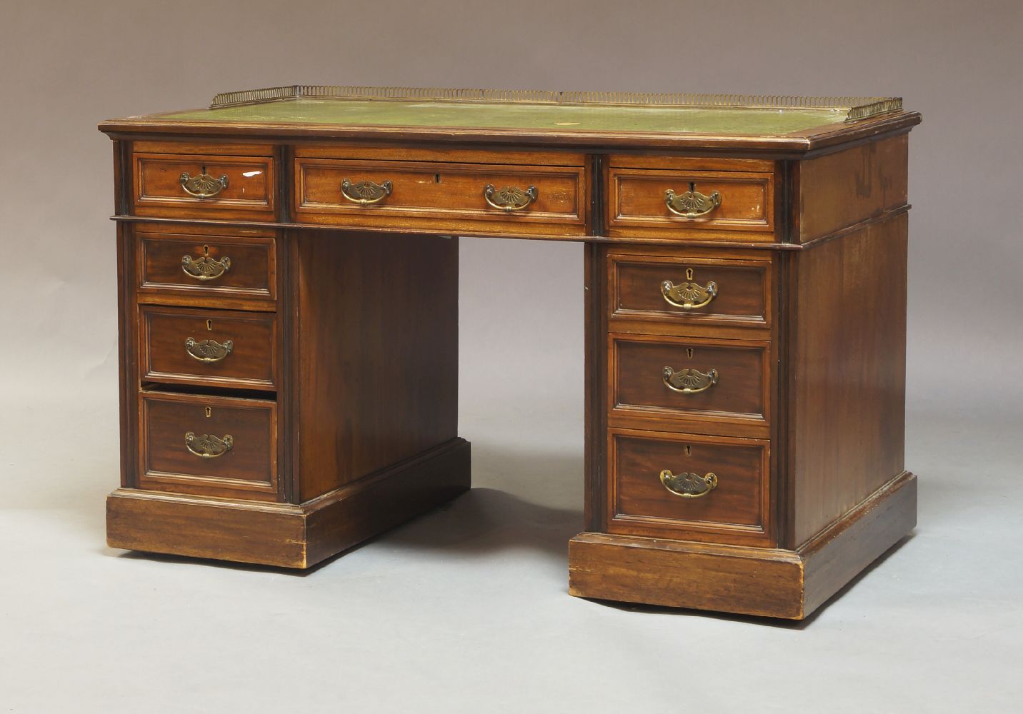 A late Victorian mahogany twin pedestal writing desk, circa 1900, the top with a brass gallery