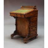 A Victorian walnut Davenport, the top surmount with lidded inkwell and stationary compartment over