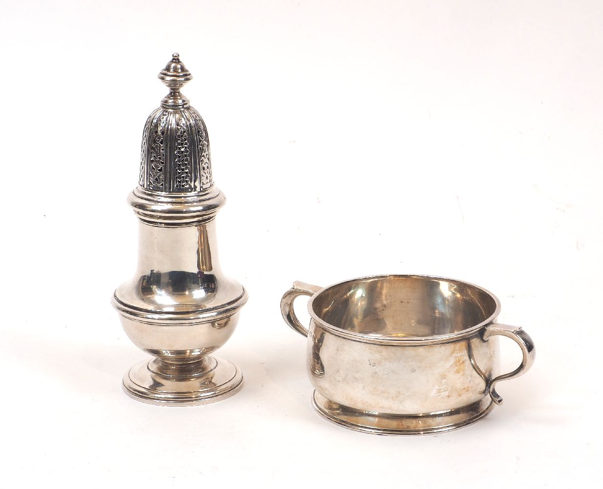 A silver sugar caster, 1974, William Comyns & Sons, together with a George V silver porringer,