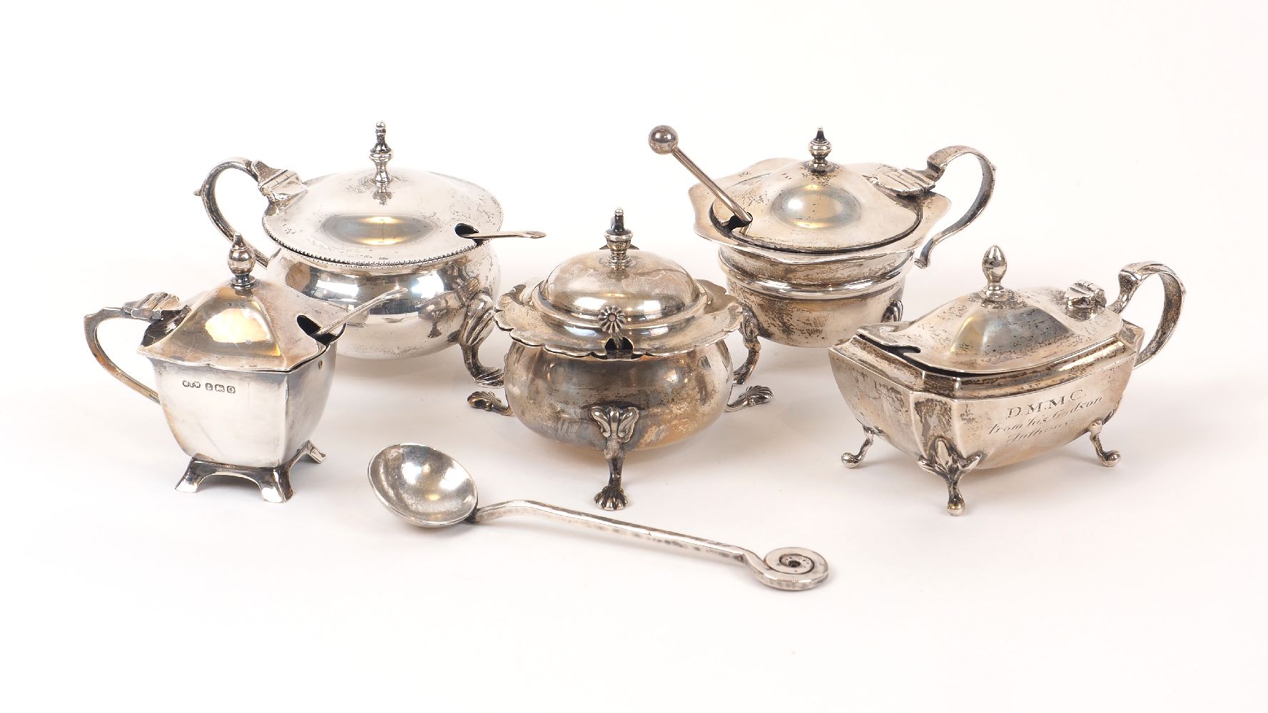 Five Edwardian and later silver mustards, and several condiment spoons, the mustards including one