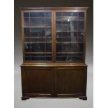 A George III and later mahogany bookcase on cabinet, the later married upper section having a