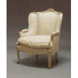 A 19th Century French Louis XV style grey painted bergere chair, having a carved crest rail,