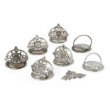 A set of seven silver plated menu holders,19th century, each pierced trefoil section decorated