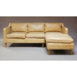 A traditional tan brown leather four seater corner settee, late 20th Century, raised on turned