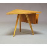 A maple veneered triangular coffee table, c.1950, with a magazine rack to one side, raised on square