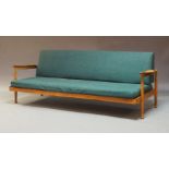 Guy Rogers, a teak 'Manhattan' sofa/day bed, circa 1960, upholstered in green, raised on turned