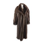 A full length raccoon fur coat, with wrap over shawl collar with large single button fastening and