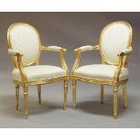 A pair of Louis XVI style giltwood fauteuils, with pale green upholstered backs and seats, raised on