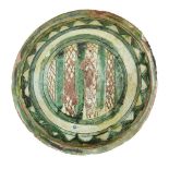 A Nishapur sgraffito pottery footed bowl, Iran, 10th century, the interior incised with a central