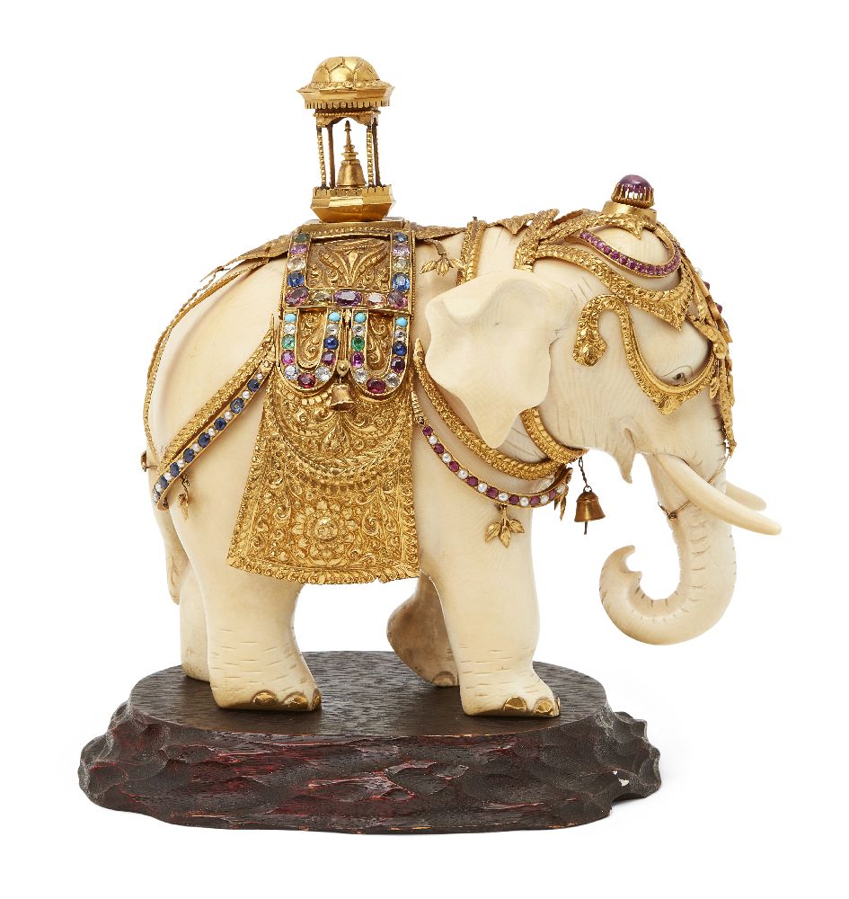 A gem-set, gilt-silver mounted ivory elephant, Ceylon (Sri Lanka), circa 1910, on an oval wood base,