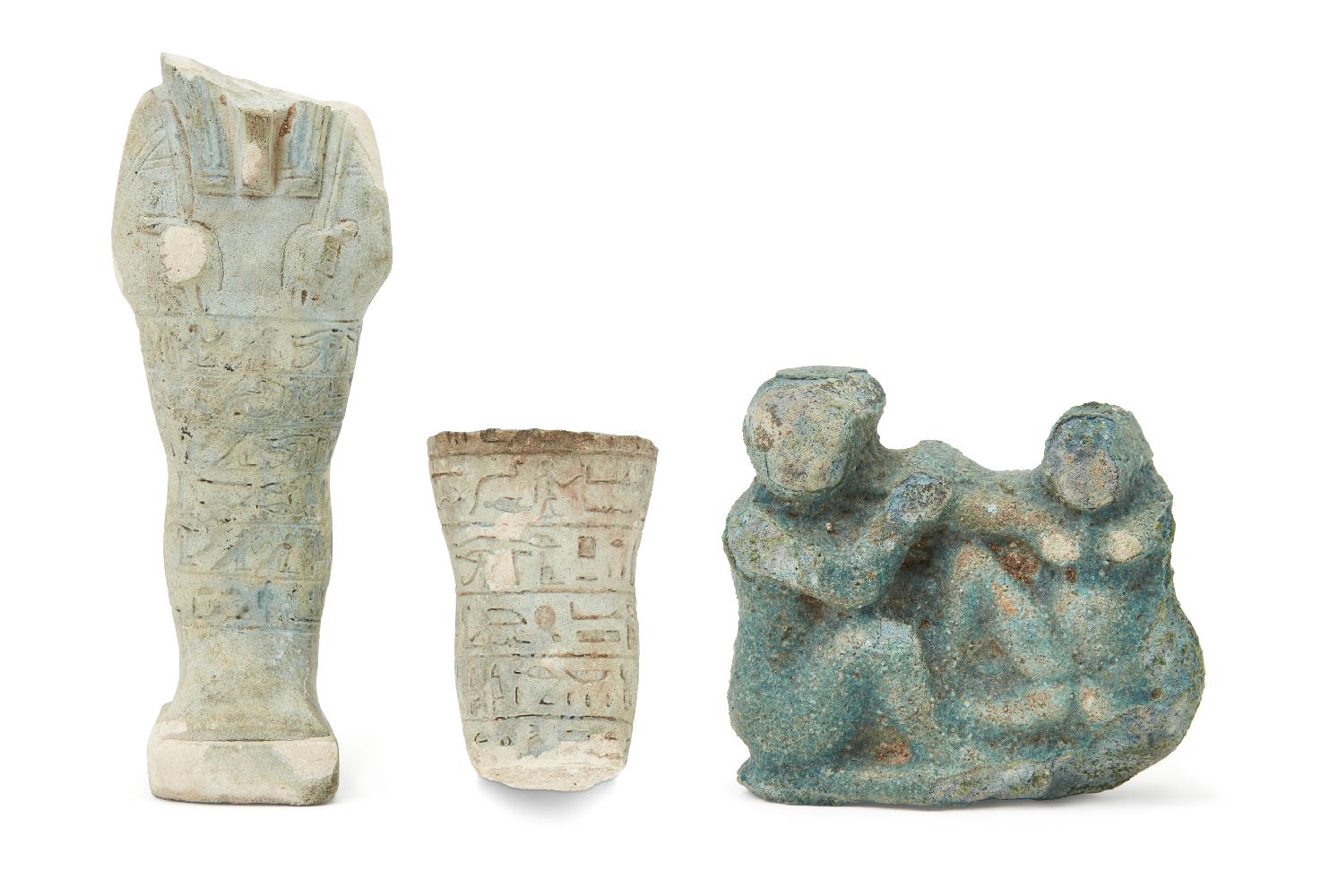 A fragmentary Egyptian blue glazed composition shabti of typical mumiform, holding two hoes, with