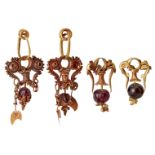 Two pairs of garnet set gold earrings in the ancient style, the first formed of three gold loops,