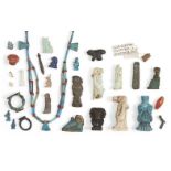 A group of 26 Egyptian amuletic pieces, including rings, in faience, stone and bronze, 18th