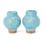 A pair of inscribed moulded Kashan turquoise glazed pottery vases, Iran, 13th century, of baluster