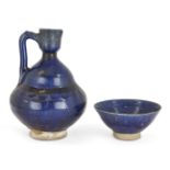 A Kashan cobalt blue glazed pottery ewer, Iran, 12th century, on spreading foot, the body rising