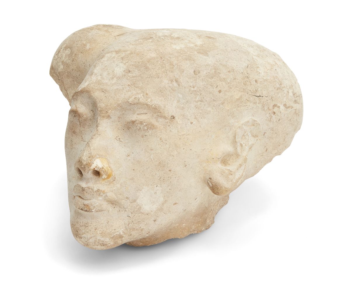 A sizeable Egyptian style limestone head of an Amarna style princess, with elongated skull with