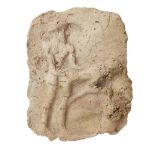 A Mesopotamian baked clay tablet with an erotic scene in high relief, the figure standing behind his