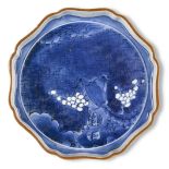 A Japanese Arita porcelain blue and white dish, c.1660-70, painted with a night-time