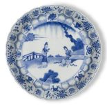 A Chinese porcelain blue and white moulded dish, Kangxi period, painted with two ladies in a garden,