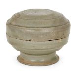 A Chinese grey stoneware celadon footed box and cover, Ming dynasty, incised to the cover with three