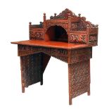 A Chinese carved and red lacquered wood writing desk, early 20th century, elaborately carved