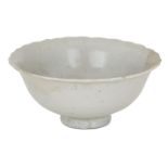 A Chinese porcelain white ware bowl, Song/Yuan dynasty, with foliate rim and moulded with vertical