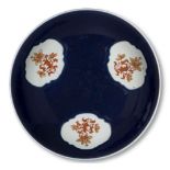 A Chinese porcelain powder blue dish, 18th century, the interior decorated with three panels of iron