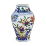 A Chinese porcelain wucai 'peaches and pomegranates' vase, 17th century, painted with vases and