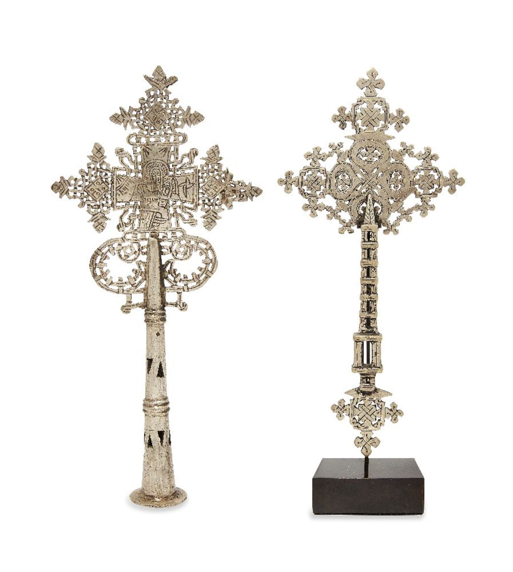 Two white metal Ethiopian Coptic crosses, mid 20th century, each with intricate design, one a