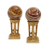 A pair of gilt-metal athenienne, late 20th century, each supporting an associated onyx sphere,