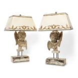 A pair of French carved wood cherub lamps, 20th century, each with traces of paint, on wood bases,