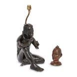 A modern bronze electrotype lamp in the form of a seated male playing a pipe, 30cm high; together