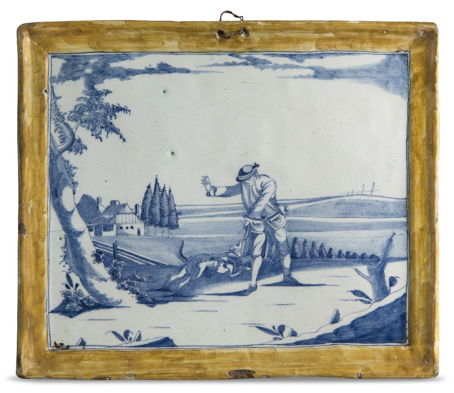 A Delft blue and white plaque, c.1760, decorated with a landscape scene featuring a dog and its
