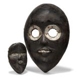 A Dan mask, Ivory Coast, 20th century, of oval form with stylised features, the circular eyes