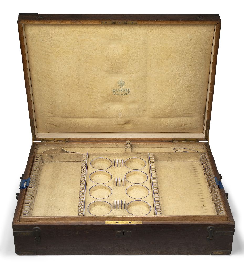 An oak canteen box with brass corners, by Faberge, no flatware within, the hinged lid opening to