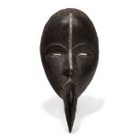 A Dan mask, Ivory Coast, 20th century, the oval face with carved stylised features, embellished with