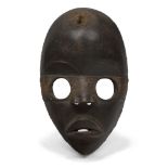 A Dan mask, Ivory Coast, 20th century, of oval form with circular eyes, stylised features and