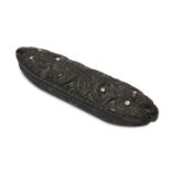 A Māori waka huia/feather box and cover, of canoe form carved with masks inset with abalone eyes,